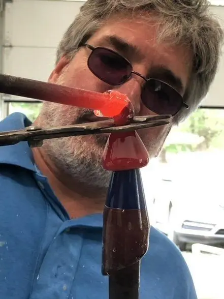 Jason Curtis shaping a red glass piece